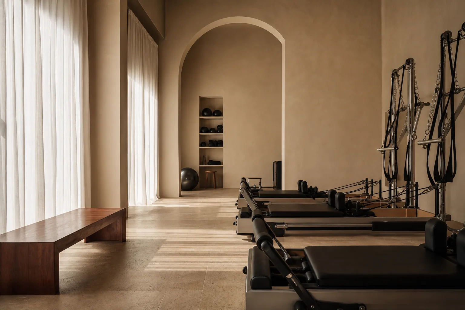 Warm sculptural resistance-training studio with limestone and linen